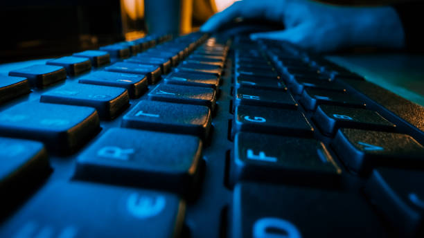 istock Close-up Moving Macro Shotof the Computer Keyboard. Working, Writing Emails, Using Internet. Dark and Blue Colors 1219143111