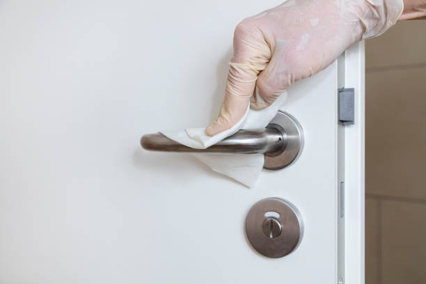 istock Female Worker Cleaning Door Handle with Antibacterial Disinfecting Wipe 1219143186