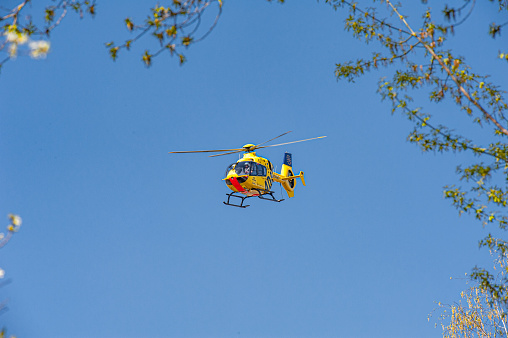 Berlin, Germany - April 12, 2020. A German rescue helicopter from ADAC fly on a sunny day over the city. Berlin, Germany.