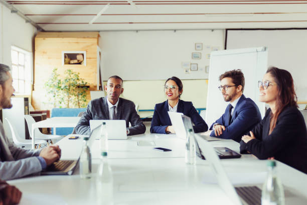 istock Group of smiling analysts communicating during meeting 1219144315