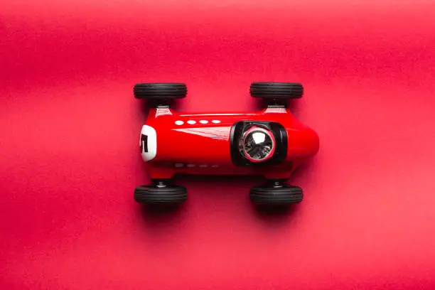 Photo of Red vintage toy racing car on a red background