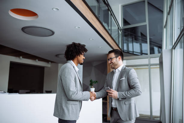 istock Diverse male employees shaking hands in hallway 1219148915