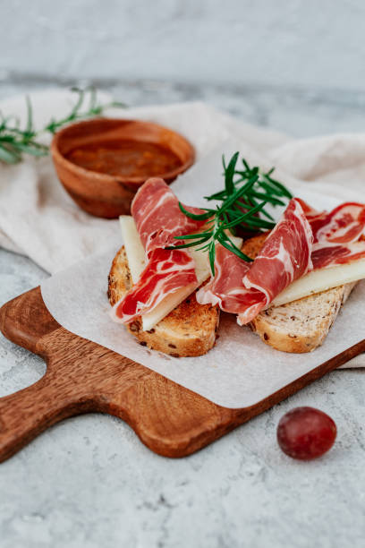 rebanadas de pan con jamón serrano español servidas como tapas - jamón de parma fotografías e imágenes de stock