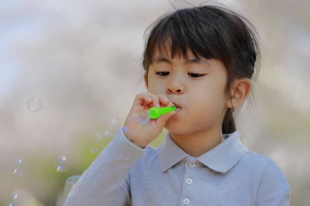 istock Japanese girl playing with bubble under the blue sky (5 years old) 1219150944