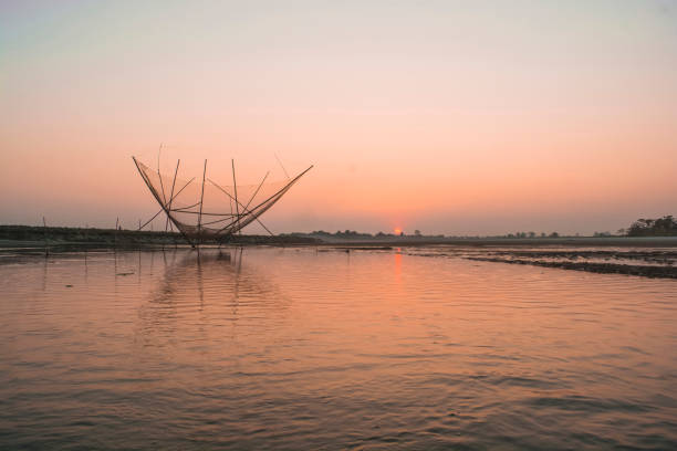 Asian fisherman prepares fishing nets for night fishing at sunset.