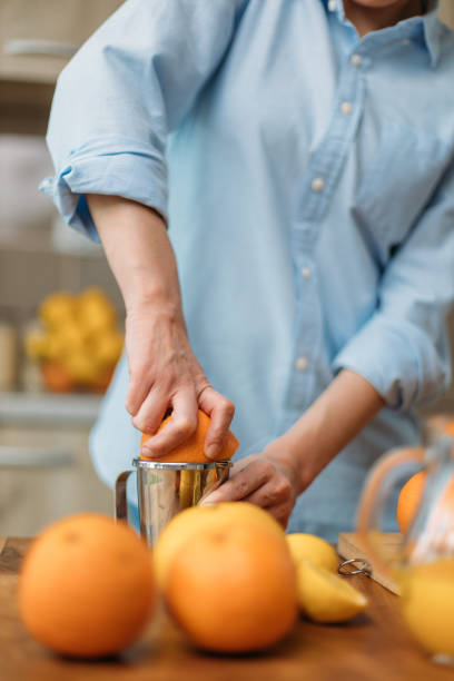 istock Young woman making juice from fresh oranges at home 1219154685