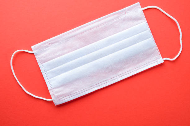 istock Protective medical mask on a red background 1219155066
