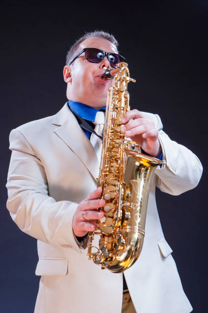 istock Caucasian Mature Playing Saxophonist Against Black Background.Vertical Image 1219156574