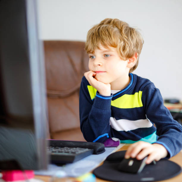 istock Little school kid boy making school homework on computer. Child learning on pc. Hard-working boy making exercise during quarantine time from corona pandemic disease. Homeschooling concept. 1219156581
