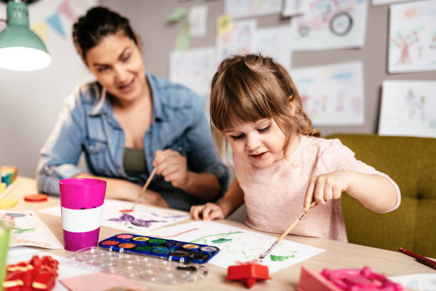 istock Cute girl drawing with mother 1219159050