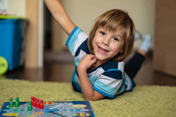 istock Happy little boy is winning at board game 1219159183