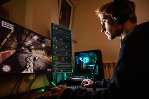 Teenage Boy Playing Multiplayer Games on Desktop Pc in his Dark Room - stock photo Teenage Boy Playing Multiplayer Games on Desktop Pc in his Dark Room casarsaguru stock pictures, royalty-free photos & images