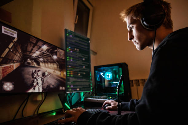 teenage boy playing multiplayer games on desktop pc in his dark room - stock photo - gaming equipment imagens e fotografias de stock