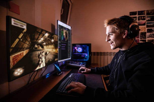 junger mann genießt es, online-multiplayer-spiele mit seinen freunden zu spielen, während in quarantäne gesperrt - stockfoto - computerspieler fotos stock-fotos und bilder