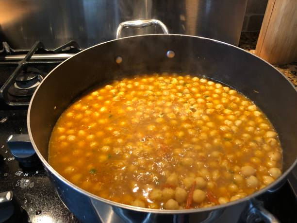 Curried chickpeas in a large pot on a stove top