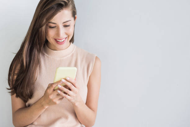istock Smiling young woman using smartphone 1219162945