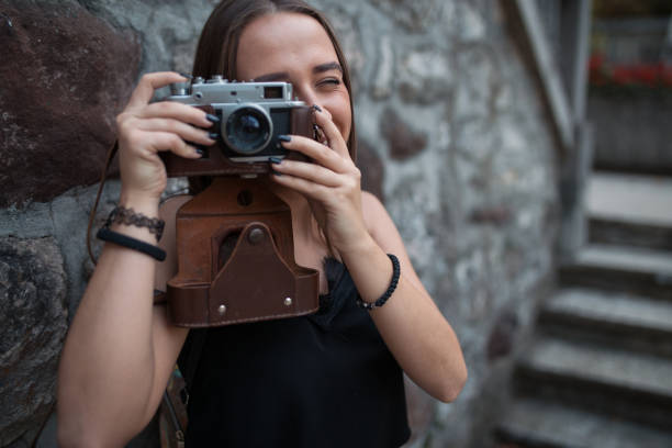 istock Young woman taking photos with camera 1219163139