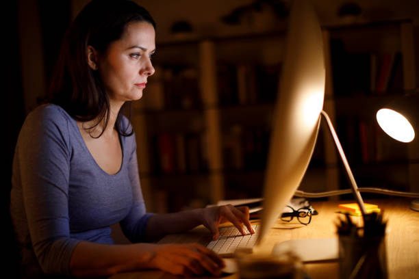 istock Woman working on computer late at home 1219163338