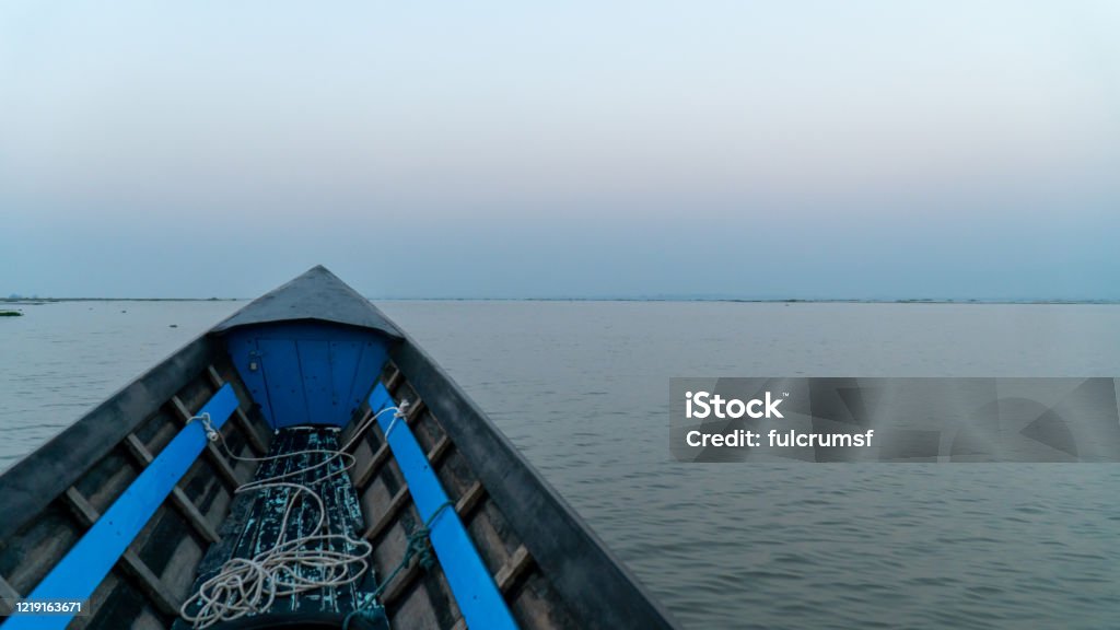Boat point of view Inle Lake Nyaungshwe, Myanmar Boat point of view Inle Lake, Myanmar. Room for copy sunrise still lake, morning mist still lake. Over twenty species of snails and nine species of fish are found nowhere else in the world. Adventure Stock Photo