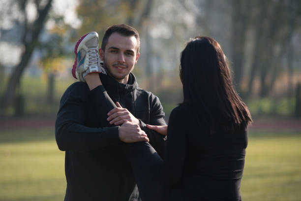 istock Couple Runner Stretching Leg in a City Park 1219165026