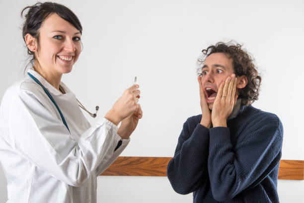 a female doctor with a syringe and with a scary patient stock photo