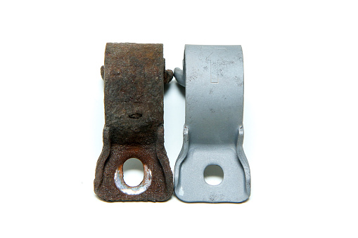 The overgrown rusty cast iron part compared with the same sand blasted part isolated in a white background.