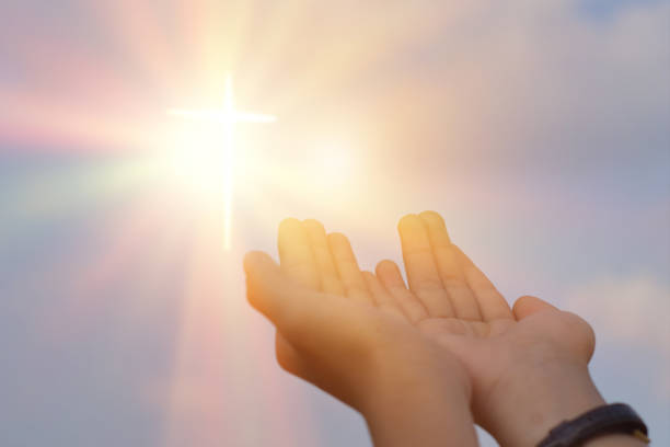 istock Hands open palm up worship over sunrise background. Catholic praying for blessing from god. 1219165844