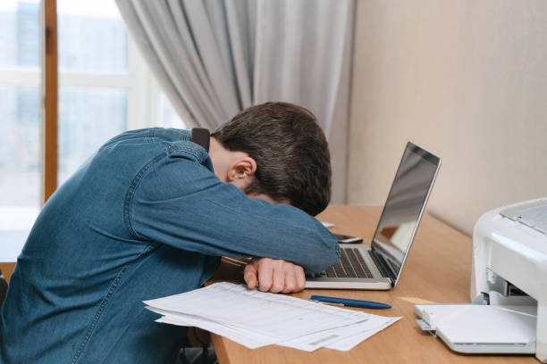 istock Upset exausted caucasian guy sleeping at workplace after hard working day 1219166440