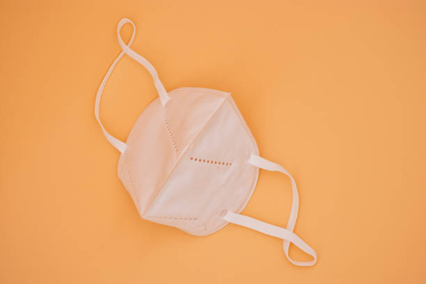 istock Face protection mask on orange background 1219167232
