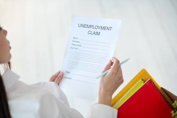 istock Female hands holding unemployment claim and pen 1219167849