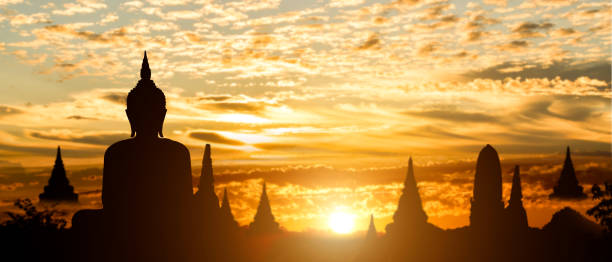 silhouette of buddha on golden temple sunset background. travel attraction in thailand. - buddhist puja imagens e fotografias de stock