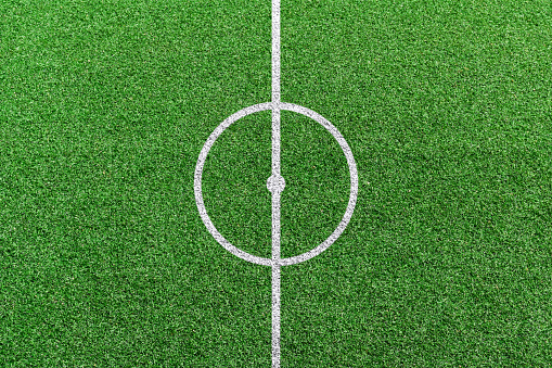 Top view of soccer field center with white lines pattern.