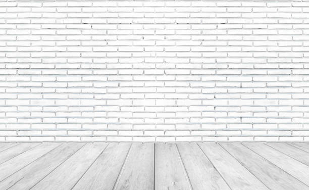 istock White empty wooden floors with brick wall background. Studio or office blank space. 1219169225
