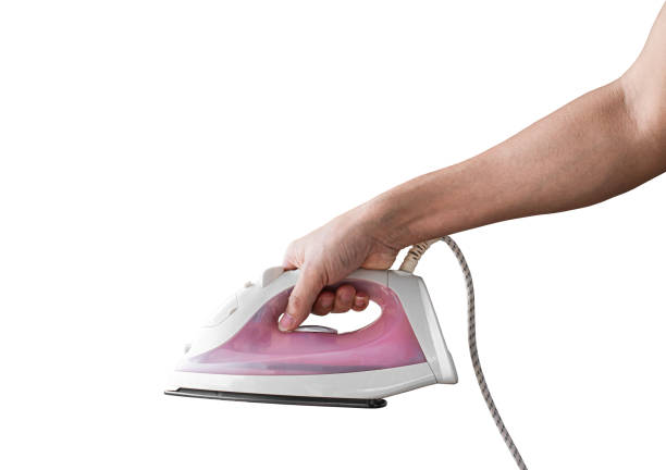 Hand holding electric iron, Isolated on white background with clipping path.
