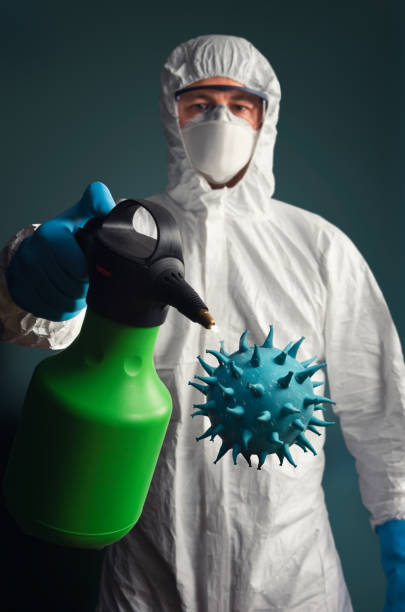 Disinfection Concept image of Male medical worker in protective suit   spraying disinfectant on virus representation biohazard cleanup stock pictures, royalty-free photos & images