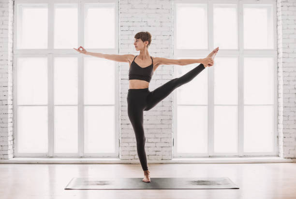 istock Young woman practicing yoga at home 1219170446