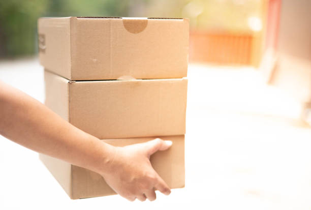 istock Delivery man hand carrying cardboard box packaging for logistic shipping. 1219170943