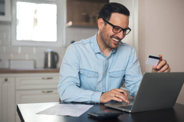 istock Man holding credit card and typing on a laptop. 1219171517