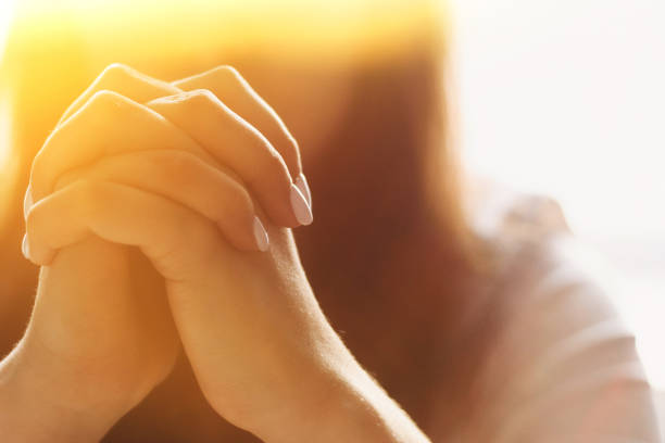 cute beautiful girl folded her hands in prayer. a woman asks god for help - rezando imagens e fotografias de stock