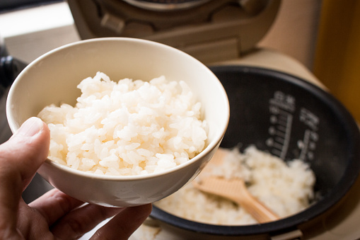 Image of Japanese style steamed rice in bowl in hand.