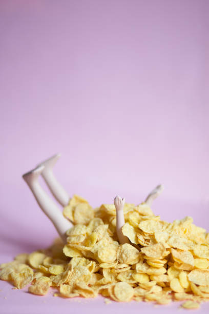 istock A doll covered with cornflakes on a pink background, gluttony, greed, diet, isolation concept 1219184290