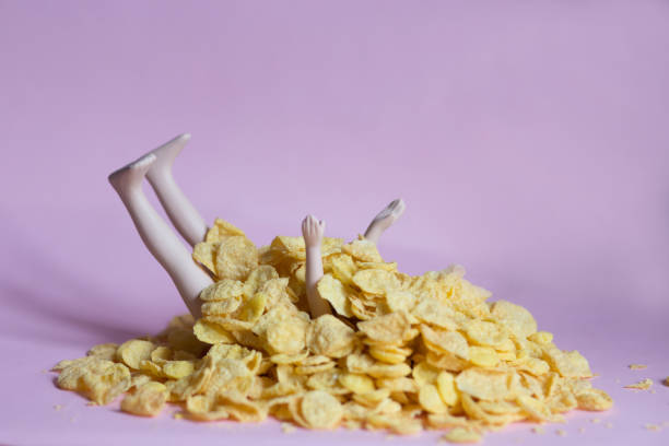 istock A doll covered with cornflakes on a pink background, gluttony, greed, diet, isolation concept 1219184300