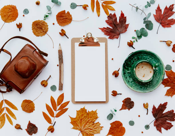istock Home office table desk workspace with clipboard decorated with autumn leaves and coffee cup. Flat lay, top view freelance business concept for social media, magazine 1219186492