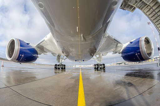 El avión de cuerpo ancho de los pasajeros está estacionado en el delantal del aeropuerto. Fuselaje de la aeronave, motor y tren de aterrizaje principal. photo