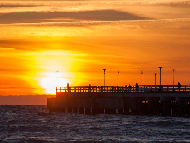 istock Sunset sea view with people on pier 1219192166
