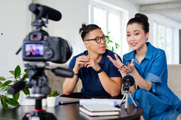 istock Friendly young woman and man vlogging 1219192713
