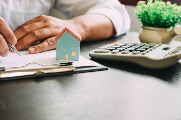 istock Businessman with Home insurance contract and calculator. 1219192952