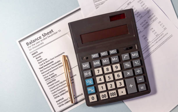 istock Calculator and golden pen on documents on grey blue table 1219193983