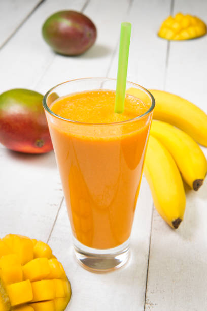 Smoothie mango with bananas and mint on a white table. Selected focus. stock photo