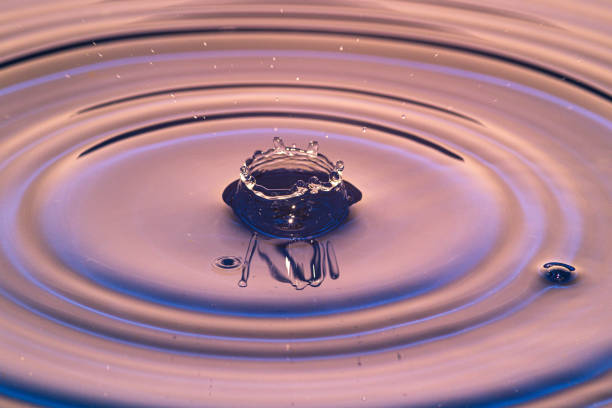 istock Splash of water crown on red surface 1219196987